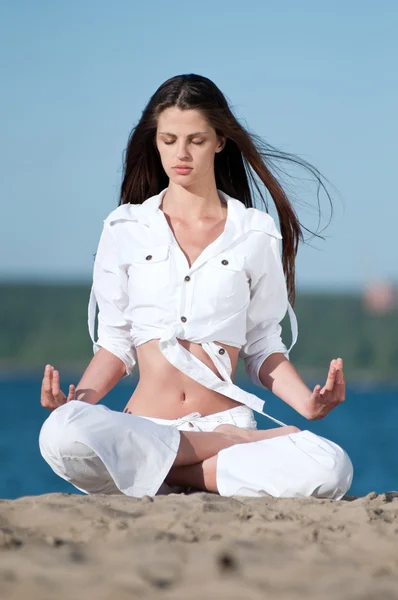 Frau praktiziert Yoga am Strand — Stockfoto