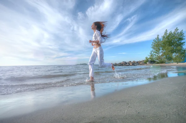 Sportiga kvinnan kör i havet — Stockfoto