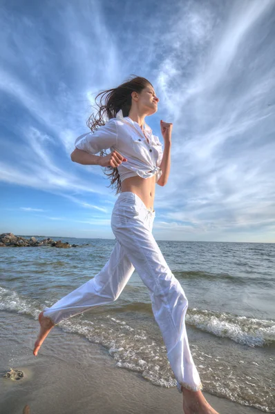 Mujer deportiva corriendo en la costa del mar —  Fotos de Stock