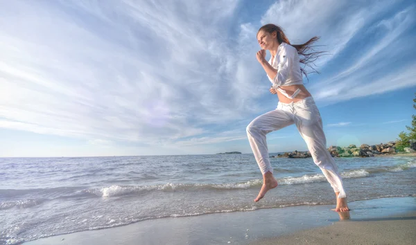 Mujer deportiva corriendo en la costa del mar —  Fotos de Stock