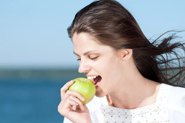 Donna sulla spiaggia mangiare frutta — Foto Stock
