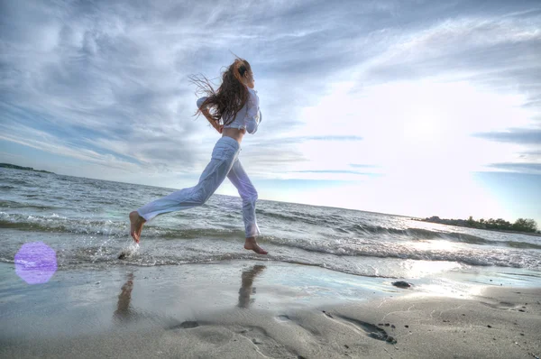 Sportiga kvinnan kör i havet — Stockfoto