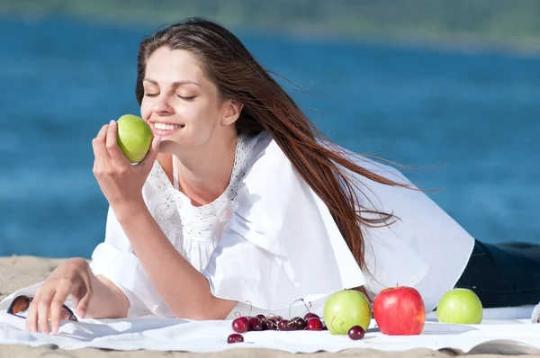 Woman on beach eating fruits — Stock Photo, Image
