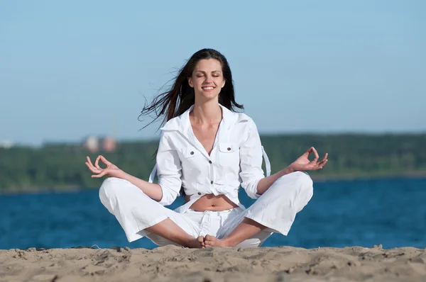 Woman practicing yoga on the beach — Stock Photo, Image