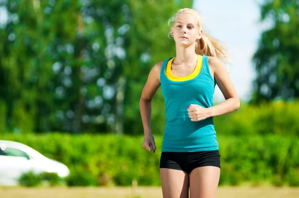 Young woman running in green park — Stock Photo, Image