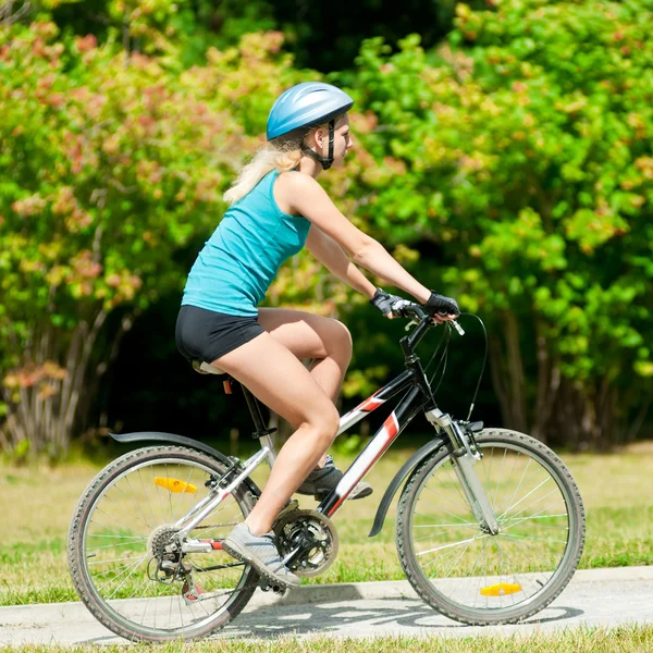Молодая улыбающаяся женщина на велосипеде — стоковое фото