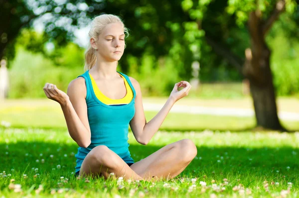 Yoga yapan genç bir kadın. — Stok fotoğraf