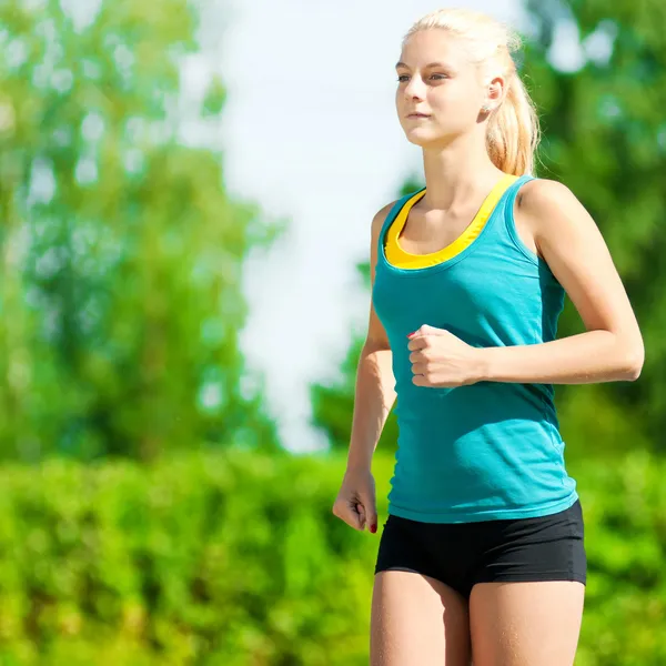 Young woman running in green park — Stock Photo, Image