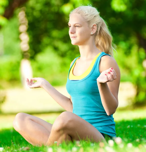 Yoga yapan genç bir kadın. — Stok fotoğraf