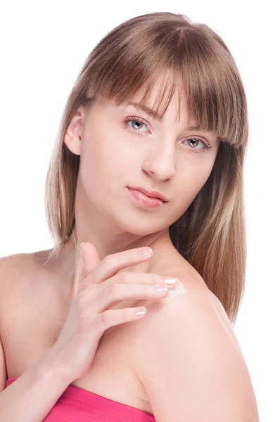 Женщина наносит крем для увлажнения на лицо — стоковое фото