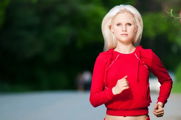 Vacker kvinna kör i park — Stockfoto