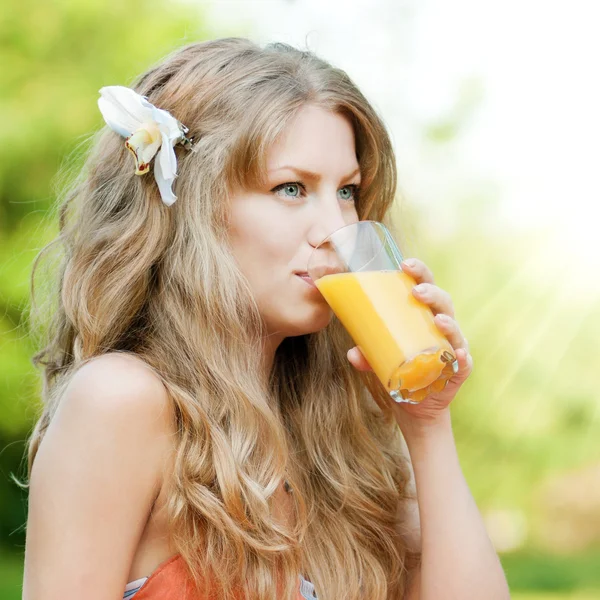 Mulher sorridente bebendo suco de laranja — Fotografia de Stock