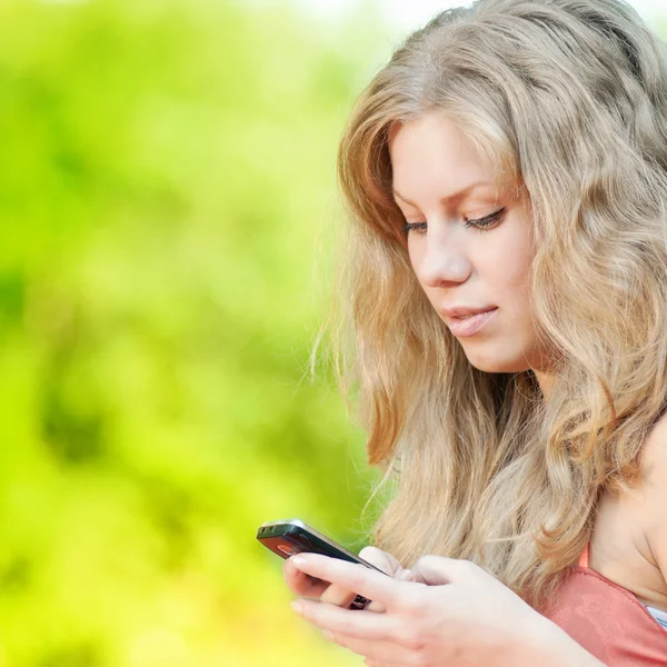 Kobieta smsy na telefon komórkowy — Zdjęcie stockowe