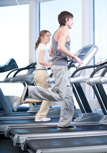 Mujer joven y hombre en el gimnasio haciendo ejercicio. Correr. — Foto de Stock