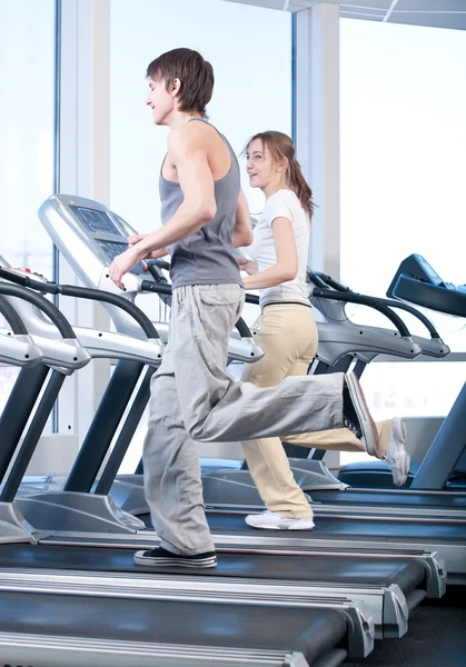 Ung kvinna och man på gym utövar. kör — Stockfoto