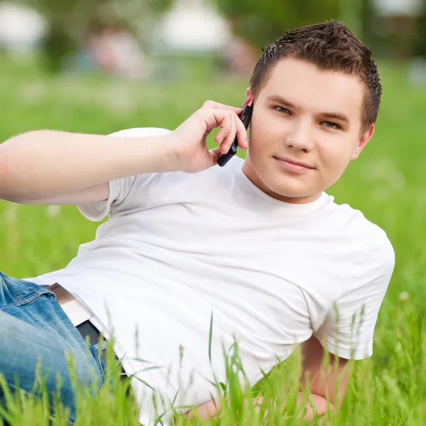 緑の都市公園で電話と若い男 — ストック写真