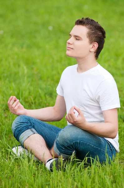 Park yoga yaparken genç bir adam — Stok fotoğraf