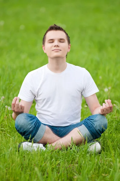 Park yoga yaparken genç bir adam — Stok fotoğraf