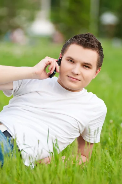 Un joven con teléfono en el parque verde de la ciudad —  Fotos de Stock