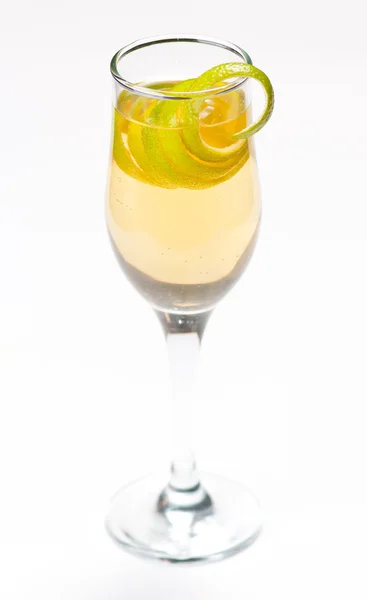 Желтый коктейль в стакане с лимонным твистом — стоковое фото