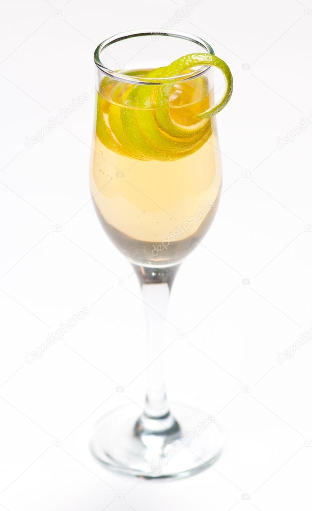 Yellow cocktail in glass with lemon twist