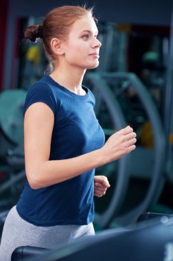 spor salonunda bir makinede çalışan genç bir kadın