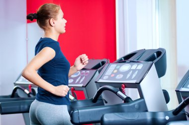 spor salonunda bir makinede çalışan genç bir kadın