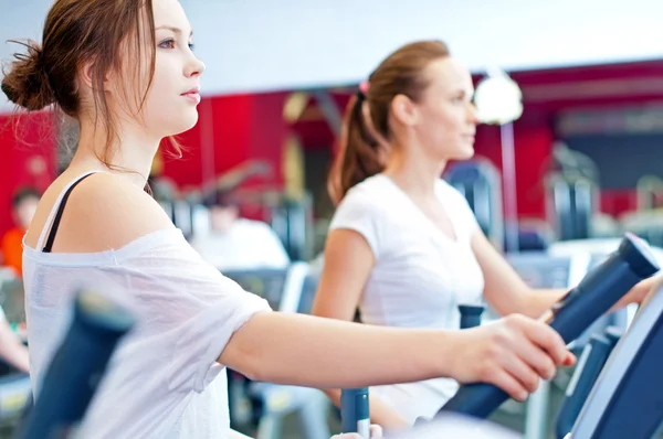 Two young sporty women run on machine — Stock Photo, Image