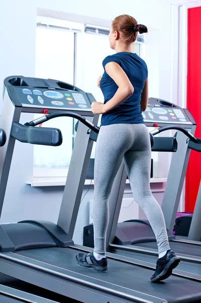 Jovem mulher no ginásio correr em uma máquina — Fotografia de Stock