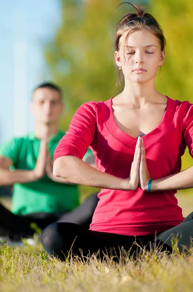 Hombre y mujer haciendo yoga en el parque —  Fotos de Stock