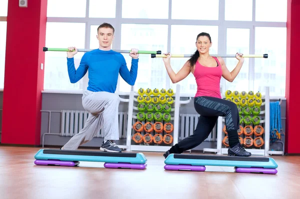 Homme et femme au gymnase faisant des étirements — Photo