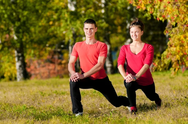 Hombre y mujer haciendo yoga en el parque —  Fotos de Stock