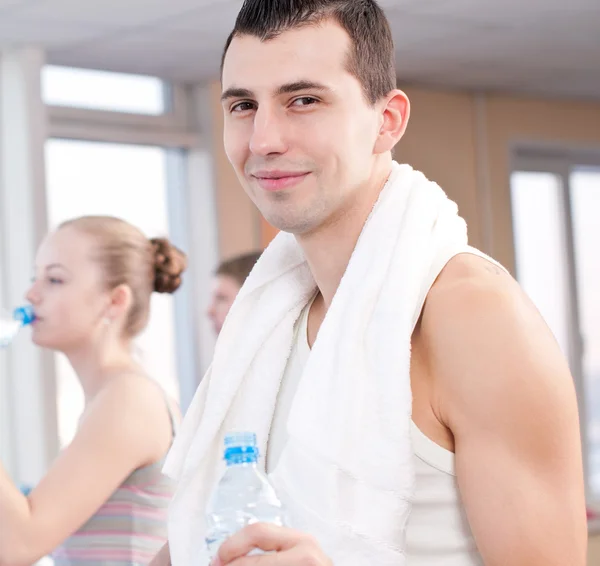 Mann und Frau trinken nach Sport in Turnhalle Wasser — Stockfoto