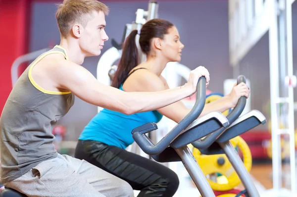 W sali gimnastycznej robi cardio trening na rowerze — Zdjęcie stockowe