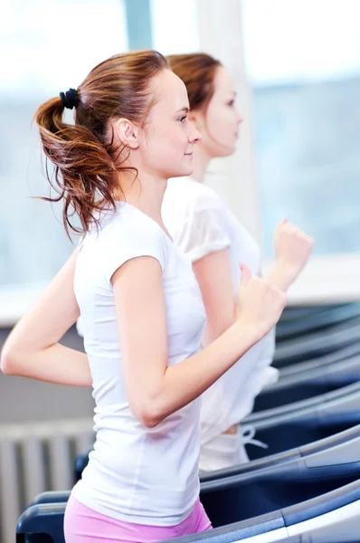 Twee jonge sportieve vrouwen draaien op machine — Stockfoto