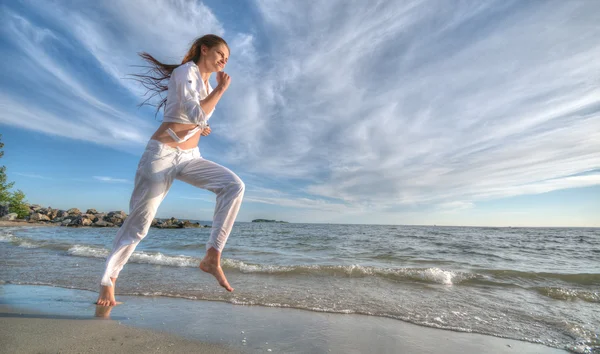 Donna sportiva che corre sulla costa del mare — Foto Stock