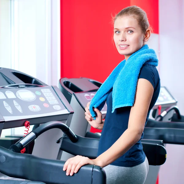 Giovane donna in palestra correre su una macchina — Foto Stock