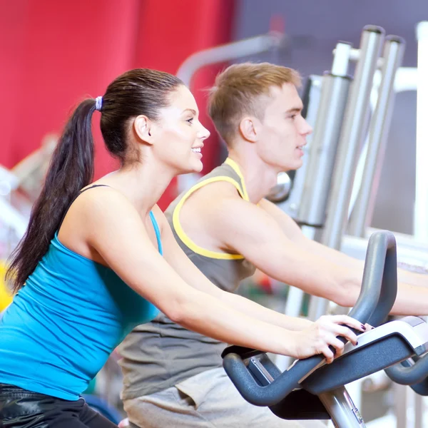 Fietsen in de sportschool doen cardio training — Stockfoto