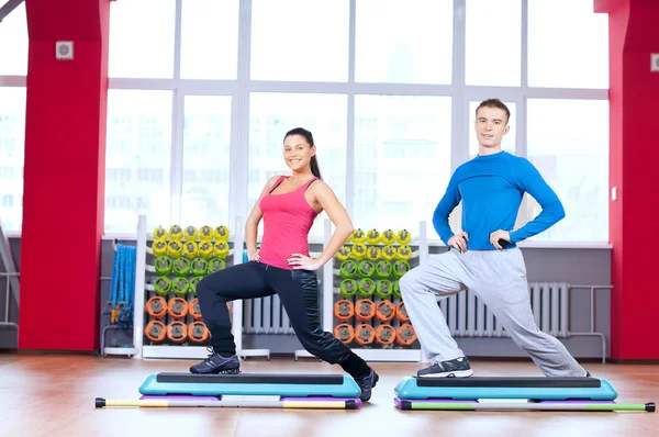 Hombre y mujer en el gimnasio haciendo estiramiento —  Fotos de Stock