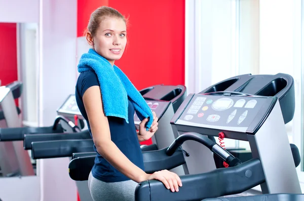 年轻女子在一台机器上运行的健身房 — 图库照片