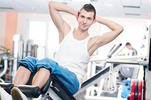 Молодой человек делает упражнения в спортзале Лицензионные Стоковые Фото