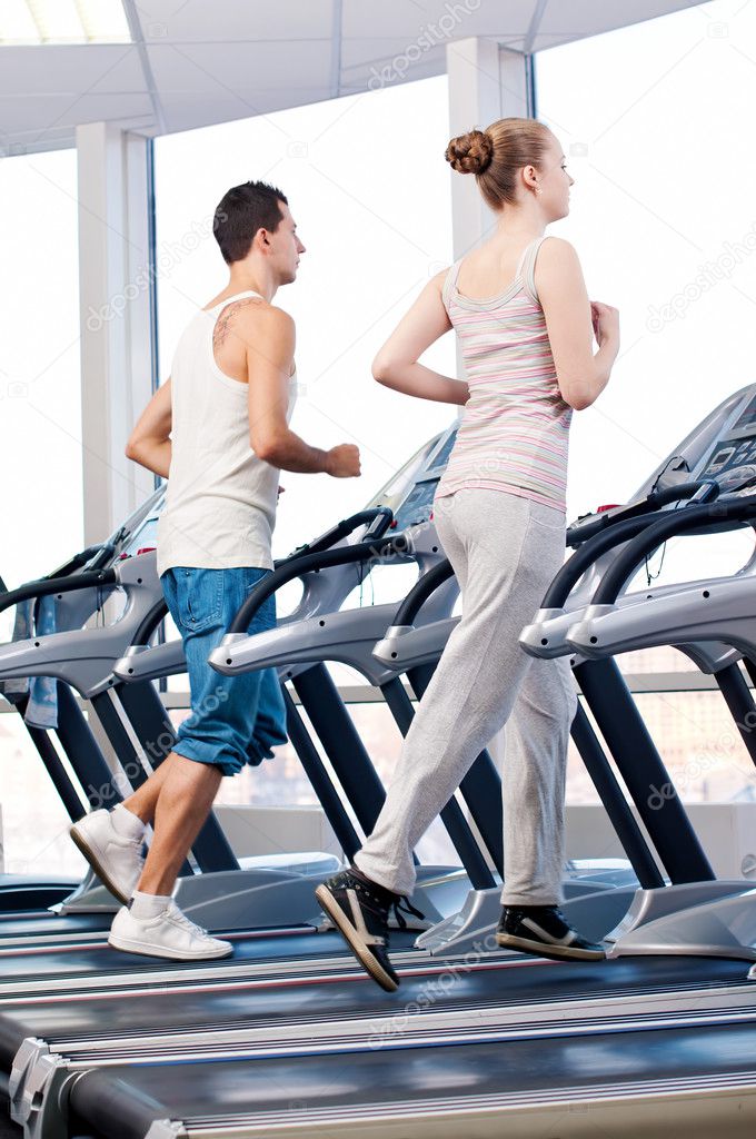 Woman and man at the gym exercising.