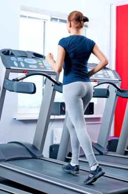 spor salonunda bir makinede çalışan genç bir kadın