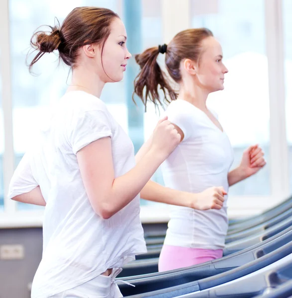 Zwei junge sportliche Frauen laufen auf Maschine — Stockfoto