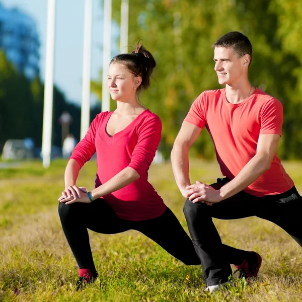 Mann und Frau beim Yoga im Park — Stockfoto