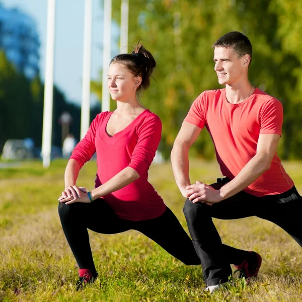 Hombre y mujer haciendo yoga en el parque — Foto de Stock