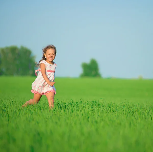 Szczęśliwy dziewczyna biegnące w polu pszenicy zielony — Zdjęcie stockowe