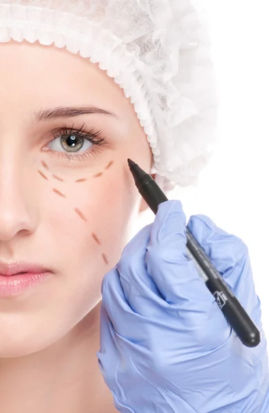 Kosmetikerin zieht Korrekturlinien auf Frauengesicht — Stockfoto