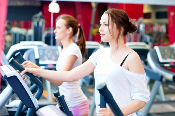 Two young sporty women run on machine — Stock Photo, Image