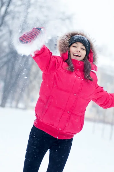 幸せな若い女性は雪と遊ぶ — ストック写真
